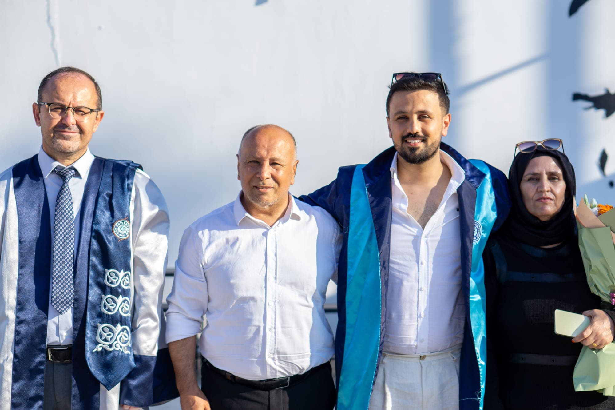 Mezuniyet töreninde aile ve öğretim üyesiyle